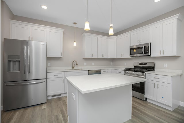 kitchen featuring recessed lighting, white cabinets, a sink, light wood-style flooring, and appliances with stainless steel finishes