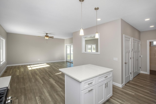 kitchen with ceiling fan, dark wood-type flooring, pendant lighting, baseboards, and white cabinetry
