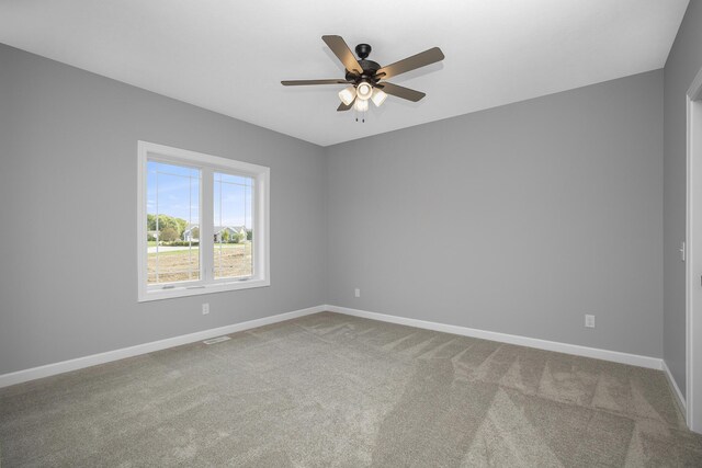 spare room with baseboards, a ceiling fan, and carpet