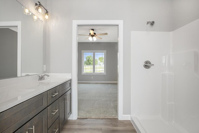 full bathroom featuring baseboards, a sink, a shower, and ceiling fan
