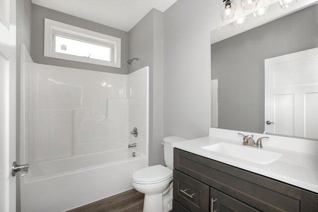 full bath featuring shower / bathing tub combination, wood finished floors, toilet, and vanity