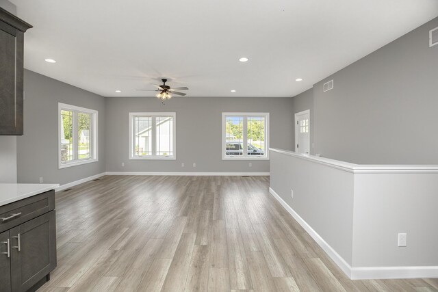 unfurnished living room featuring recessed lighting, light wood-style floors, a ceiling fan, and baseboards