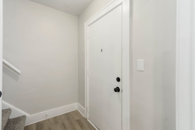 entryway with light wood-style floors, baseboards, and stairway