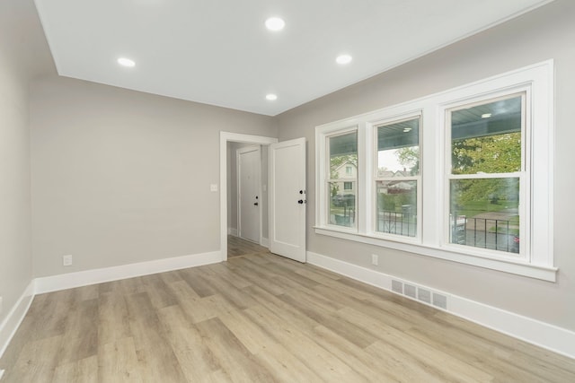 unfurnished room featuring baseboards, visible vents, a healthy amount of sunlight, and light wood-style flooring