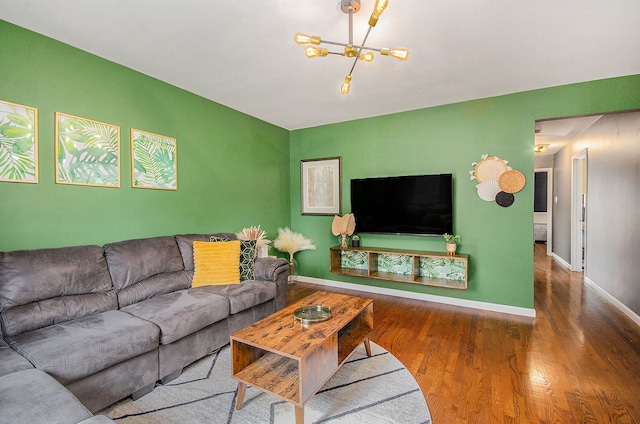 living room featuring an inviting chandelier, baseboards, and wood finished floors