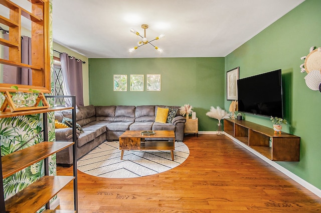 living area featuring baseboards, an inviting chandelier, and wood finished floors