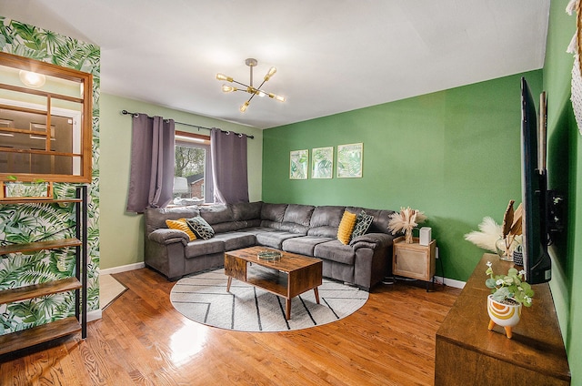 living room with an inviting chandelier, baseboards, and wood finished floors