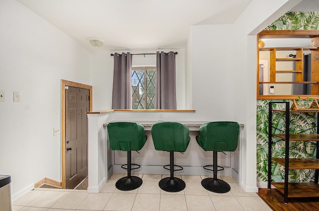 interior space with baseboards and tile patterned flooring