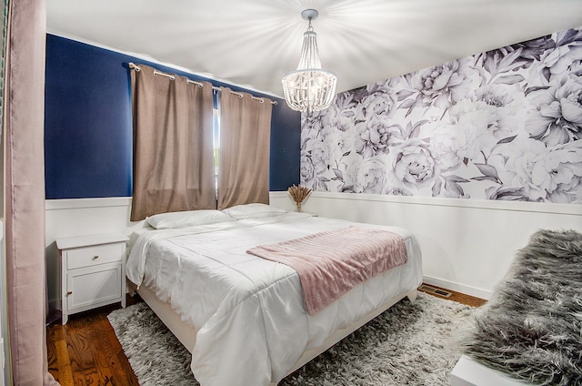 bedroom featuring a chandelier, wood finished floors, and visible vents