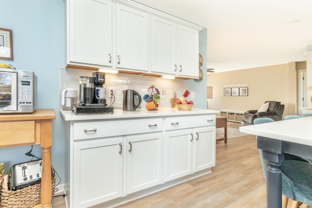 48320 Martz Rd, Michigan, MI 48111 - kitchen with backsplash, light countertops, stainless steel microwave, light wood-style floors, and open floor plan