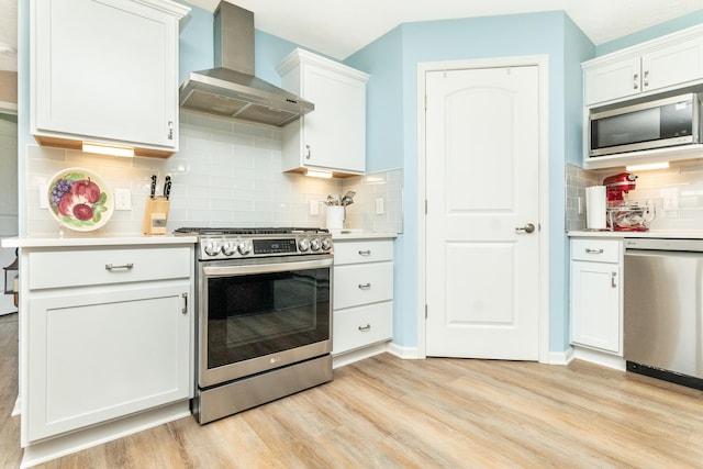 48320 Martz Rd, Michigan, MI 48111 - kitchen featuring wall chimney exhaust hood, light wood-style flooring, backsplash, light countertops, and appliances with stainless steel finishes