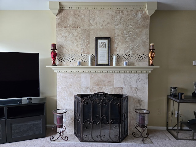 living room featuring a tile fireplace, baseboards, and carpet floors