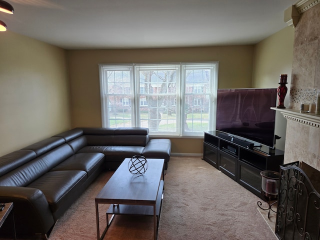 carpeted living area with a fireplace and baseboards