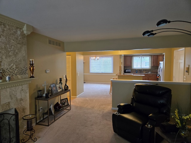 living room with baseboards, light carpet, an inviting chandelier, and visible vents