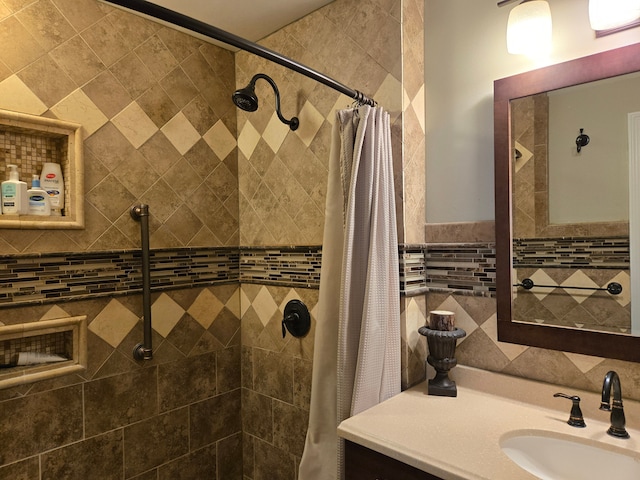 full bath featuring tile walls, vanity, and a tile shower