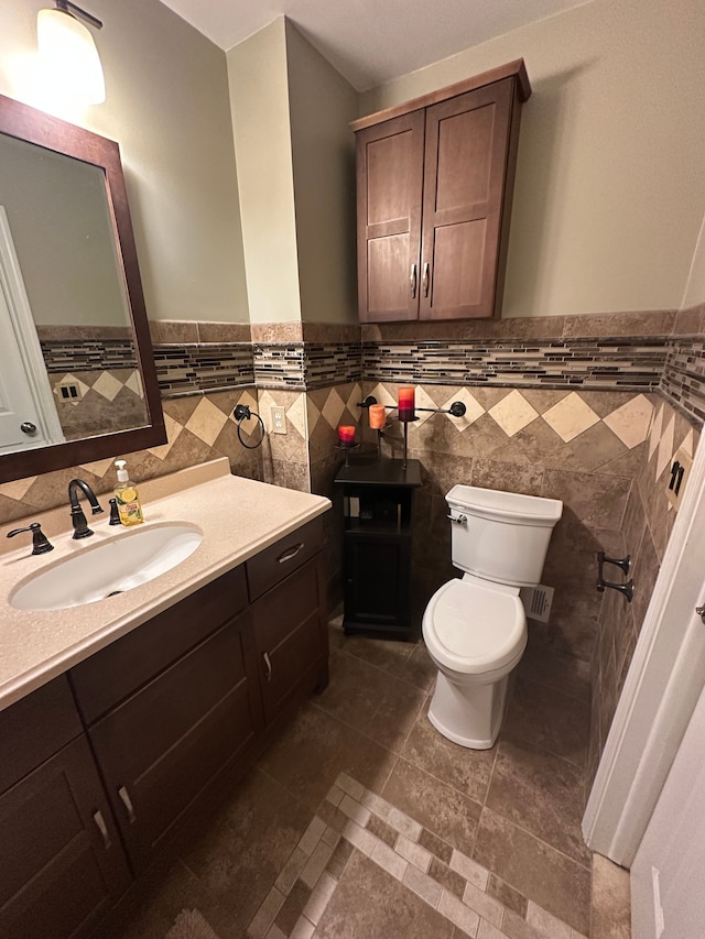 half bathroom featuring toilet, tile walls, and a wainscoted wall