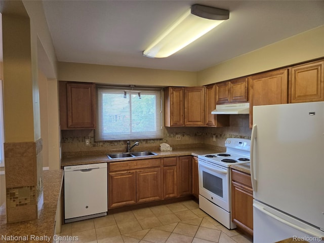 450 Billingsgate Unit C, Bloomfield Hills, MI 48301 - kitchen with white appliances, under cabinet range hood, brown cabinetry, light tile patterned flooring, and backsplash