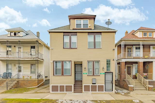 view of front of home with a porch, entry steps, and a balcony