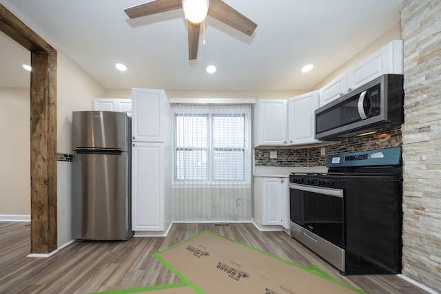 kitchen featuring light wood-style flooring, ceiling fan, white cabinetry, and stainless steel appliances