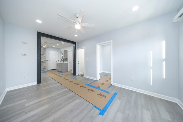 interior space with light wood-style floors, ensuite bath, and baseboards