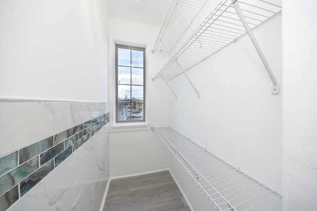 walk in closet with wood finished floors