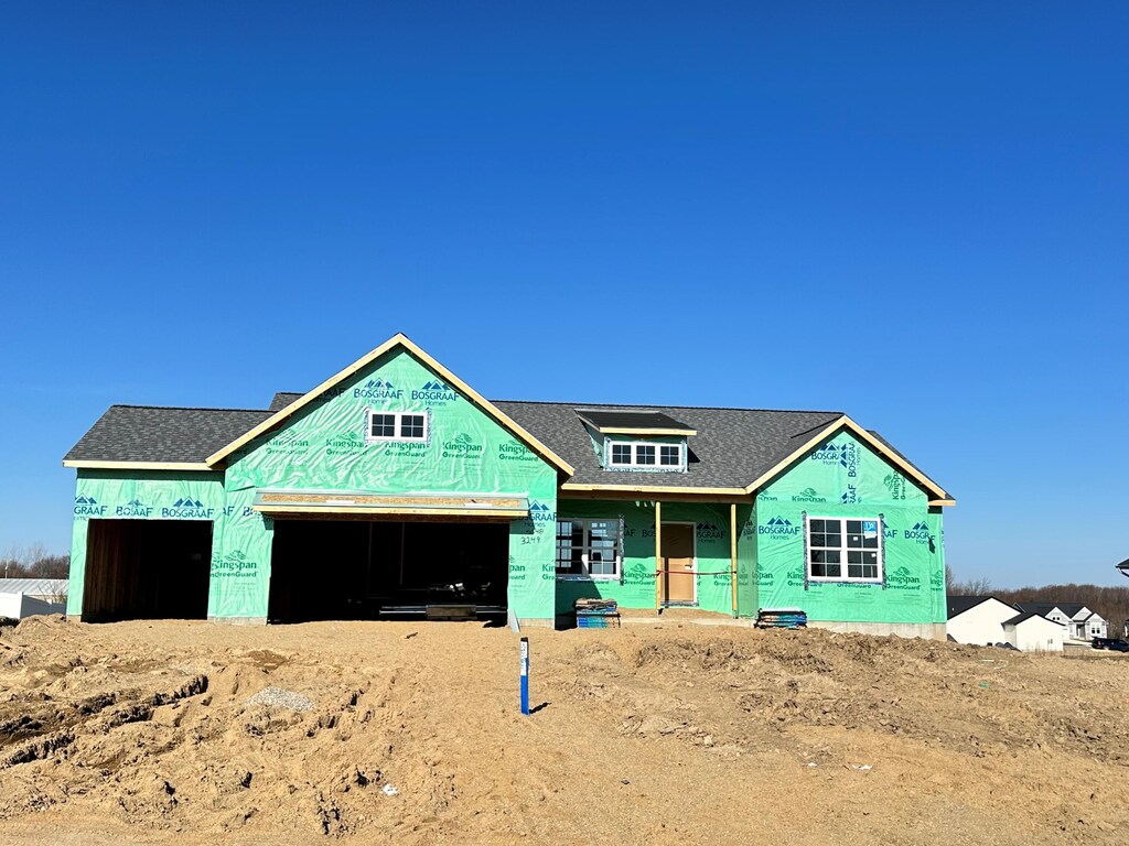 property under construction with roof with shingles and a garage