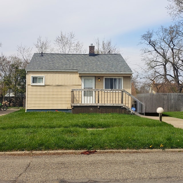 33 E Fairmount Ave, Pontiac, MI 48340 - view of front of home featuring a chimney, a front lawn, fence, and a shingled roof