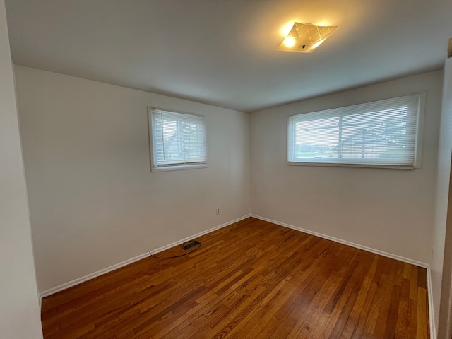 unfurnished room featuring baseboards, a healthy amount of sunlight, and hardwood / wood-style floors