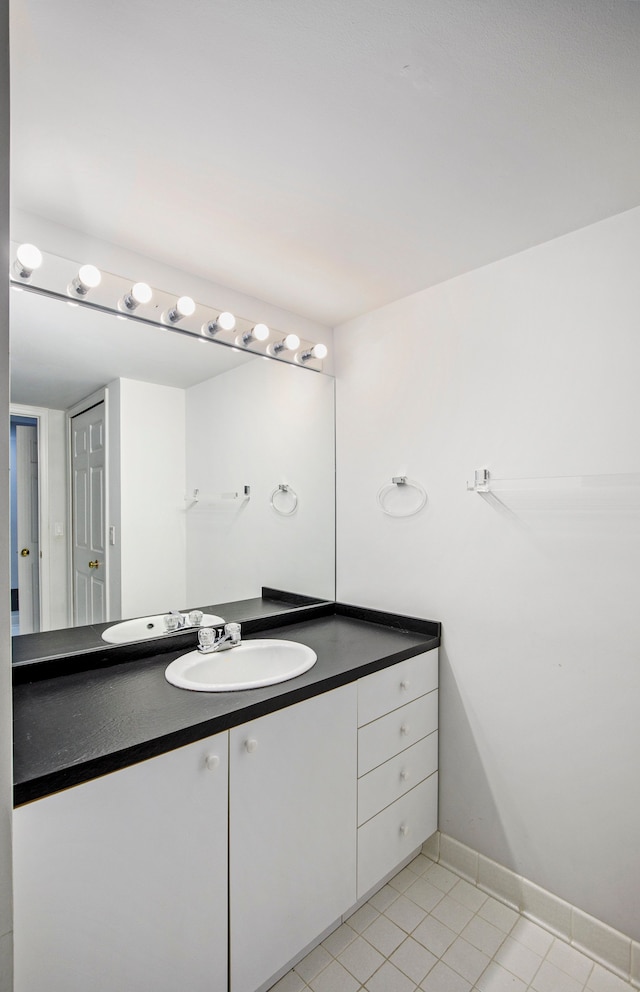 bathroom featuring baseboards, tile patterned flooring, and vanity