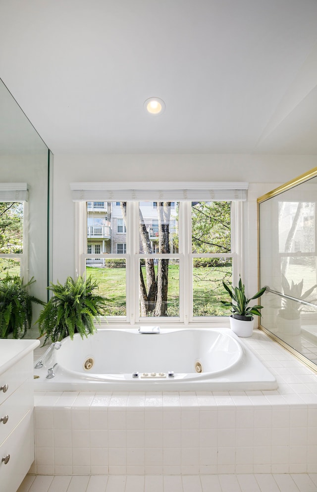 full bath with a whirlpool tub, recessed lighting, and vanity