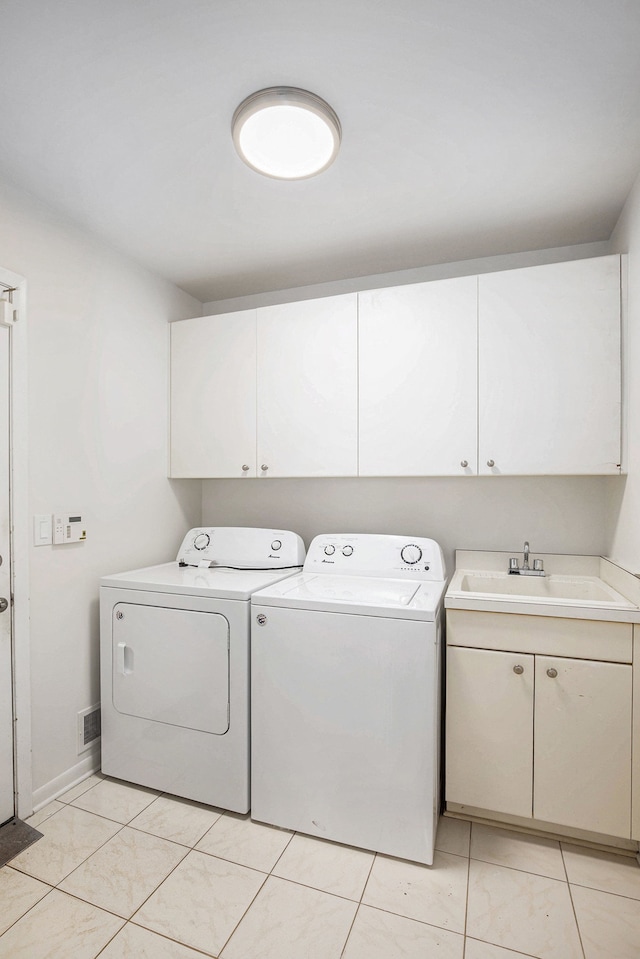 laundry room with a sink, cabinet space, light tile patterned floors, visible vents, and washer and dryer