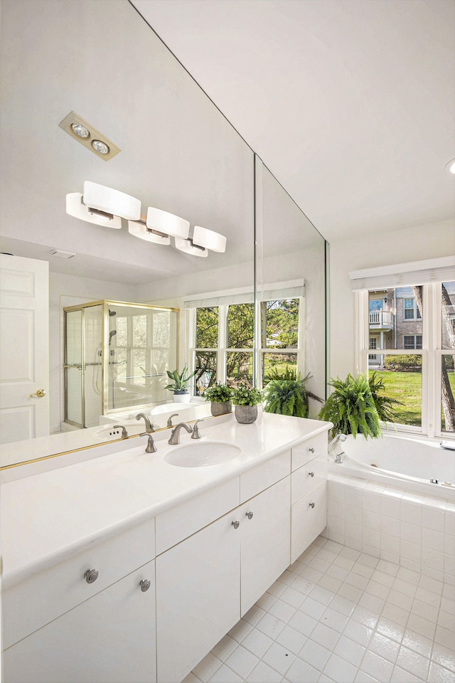 full bath featuring a stall shower, tile patterned flooring, tiled tub, and vanity