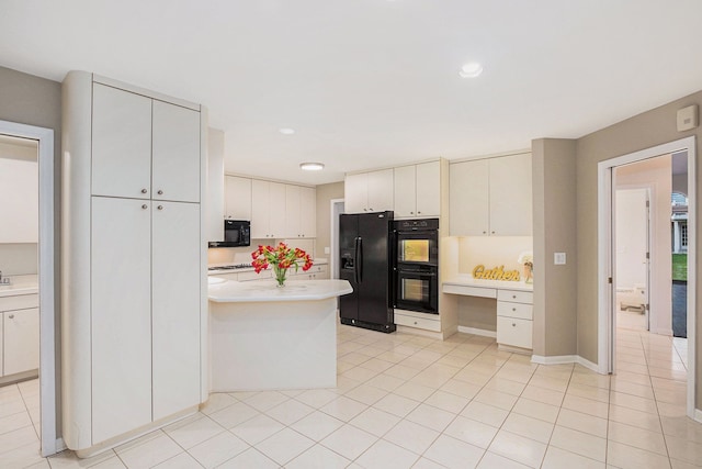 kitchen with recessed lighting, light tile patterned floors, black appliances, a peninsula, and light countertops
