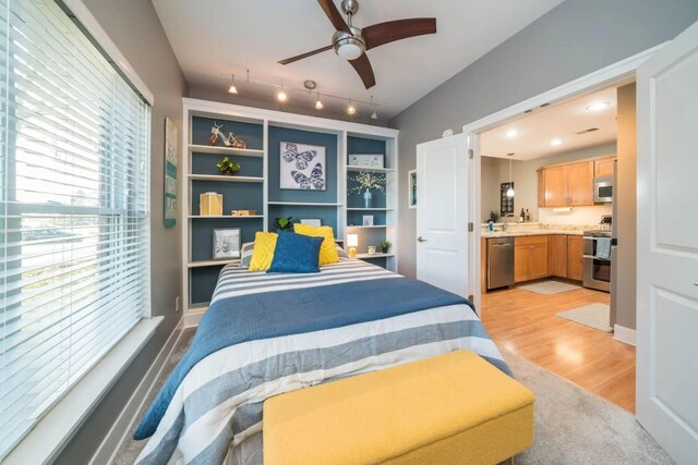 bedroom with connected bathroom and light wood-style floors