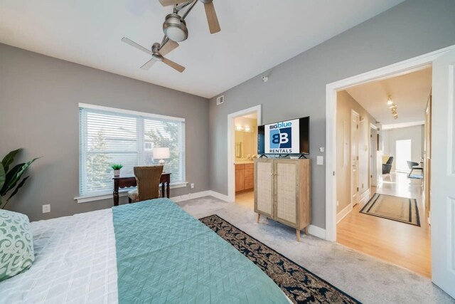 bedroom with a ceiling fan, light carpet, baseboards, ensuite bath, and visible vents