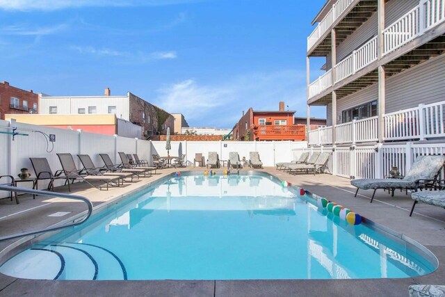 community pool featuring a patio area and fence