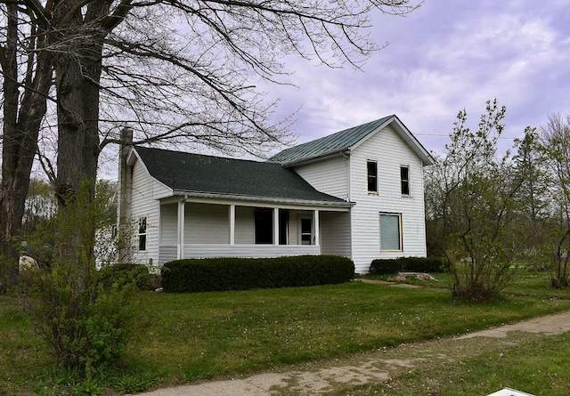325 E Leroy St, Burlington, MI 49029 - traditional home with a chimney, a front lawn, and metal roof