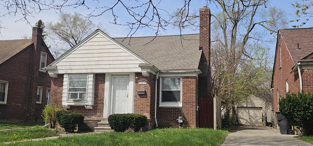 12673 Mettetal St, Detroit, MI 48227 - view of front of home featuring an outbuilding, a chimney, concrete driveway, brick siding, and a shingled roof
