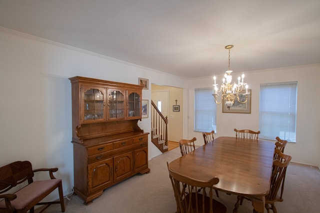 dining space featuring light colored carpet, crown molding, a chandelier, and stairway
