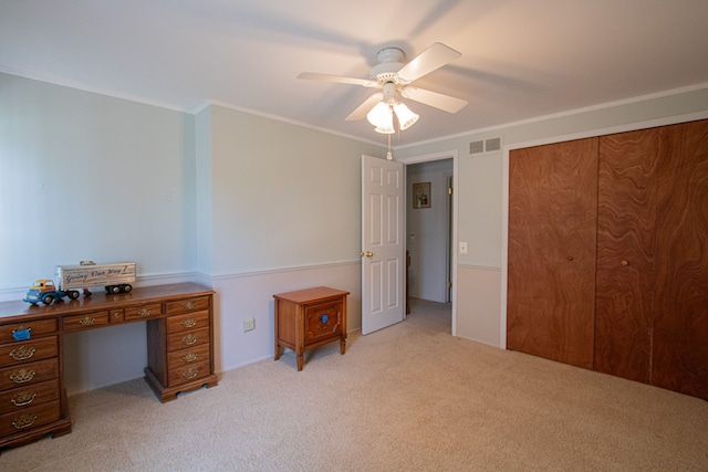 unfurnished bedroom featuring ceiling fan, light carpet, visible vents, ornamental molding, and a closet