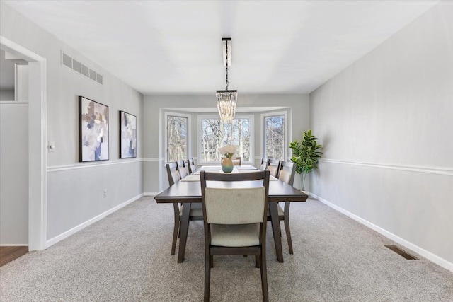 dining area featuring baseboards, visible vents, and carpet