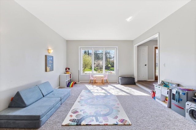 playroom featuring baseboards, carpet, and washer / dryer