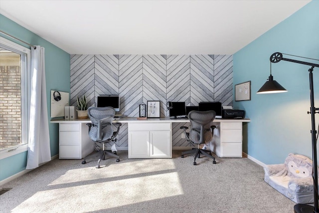 home office featuring baseboards, an accent wall, and carpet
