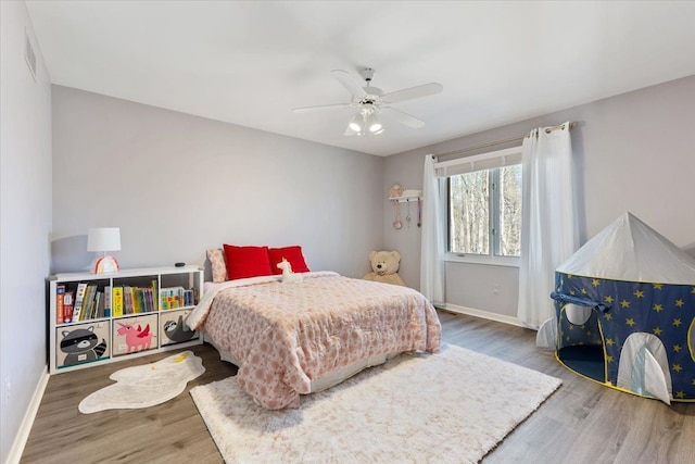 bedroom featuring wood finished floors, visible vents, baseboards, and ceiling fan