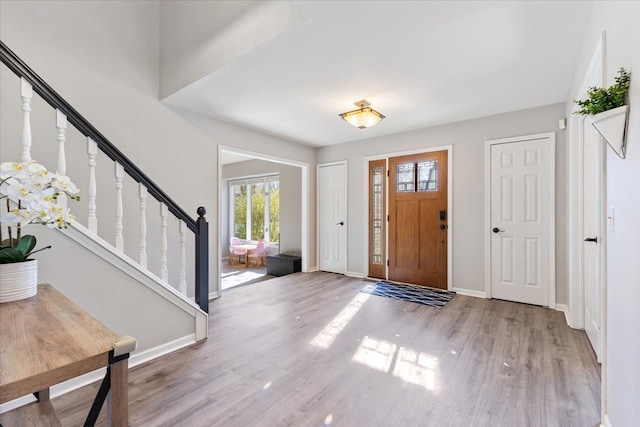 foyer featuring stairway, baseboards, and wood finished floors