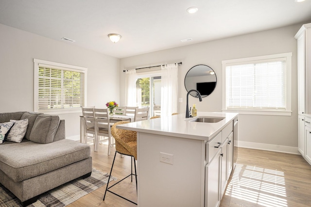 742 Ravine Ln, South Haven, MI 49090 - kitchen with a kitchen breakfast bar, a sink, visible vents, baseboards, and light countertops