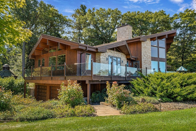 5788 M 63, Coloma, MI 49038 - rear view of property with stone siding, a wooden deck, a chimney, and a garage