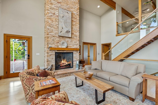 5788 M 63, Coloma, MI 49038 - living room with light wood-style flooring, baseboards, stairway, a fireplace, and high vaulted ceiling