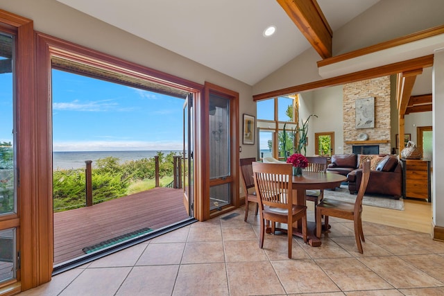 5788 M 63, Coloma, MI 49038 - dining area with a stone fireplace, lofted ceiling with beams, light tile patterned floors, a water view, and visible vents