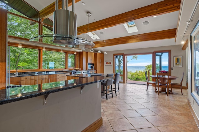 5788 M 63, Coloma, MI 49038 - kitchen with a sink, a water view, dark stone counters, light tile patterned flooring, and a breakfast bar